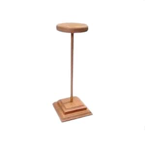 May include: A wooden hat stand with a round top and a square base. The stand is made of light brown wood.