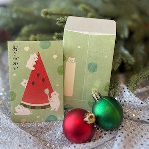 May include: Two light green paper envelopes featuring illustrations of small white bears. One envelope displays a large red watermelon slice with black seeds and Japanese text. The other envelope has a small bear peeking over a rectangular white space.