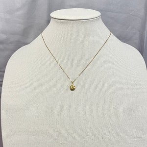 May include: A gold chain necklace with a small gold fortune cookie pendant.