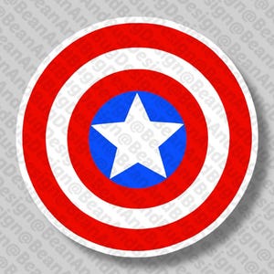 Puede incluir: Una pegatina redonda con un diseño de escudo en rojo, blanco y azul. El escudo tiene círculos concéntricos rojos y blancos, con un círculo azul en el centro. Una estrella blanca está en el centro del círculo azul.