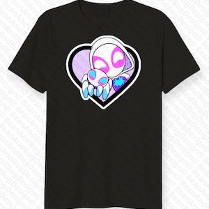 Op de afbeelding: Zwart T-shirt met een witte en roze hartvormige afbeelding met een wit en roze cartoonfiguur dat een kleiner blauw en roze cartoonfiguur vasthoudt.