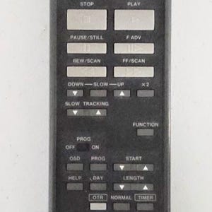 May include: A black GE remote control with numerous buttons for power, channel selection, and playback functions. The remote has a rectangular shape and features the GE logo at the bottom.