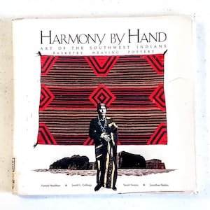 May include: Book cover with the title "Harmony by Hand: Art of the Southwest Indians" with a red, black, and white geometric pattern and a person wearing a traditional Native American outfit standing in front of a desert landscape.