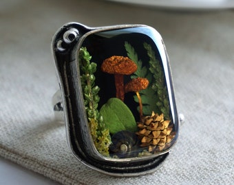 Forest ring with real mushrooms, cranberry leaf, lichen, fern, cone, heather and snail shell.