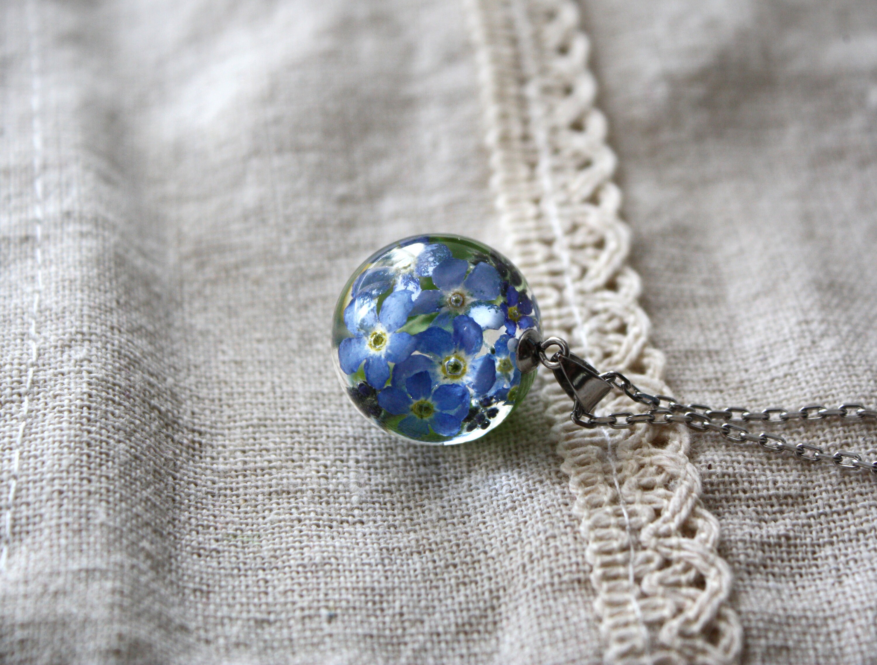 Delicate transparent resin pendant with real Forget Me Nots encased