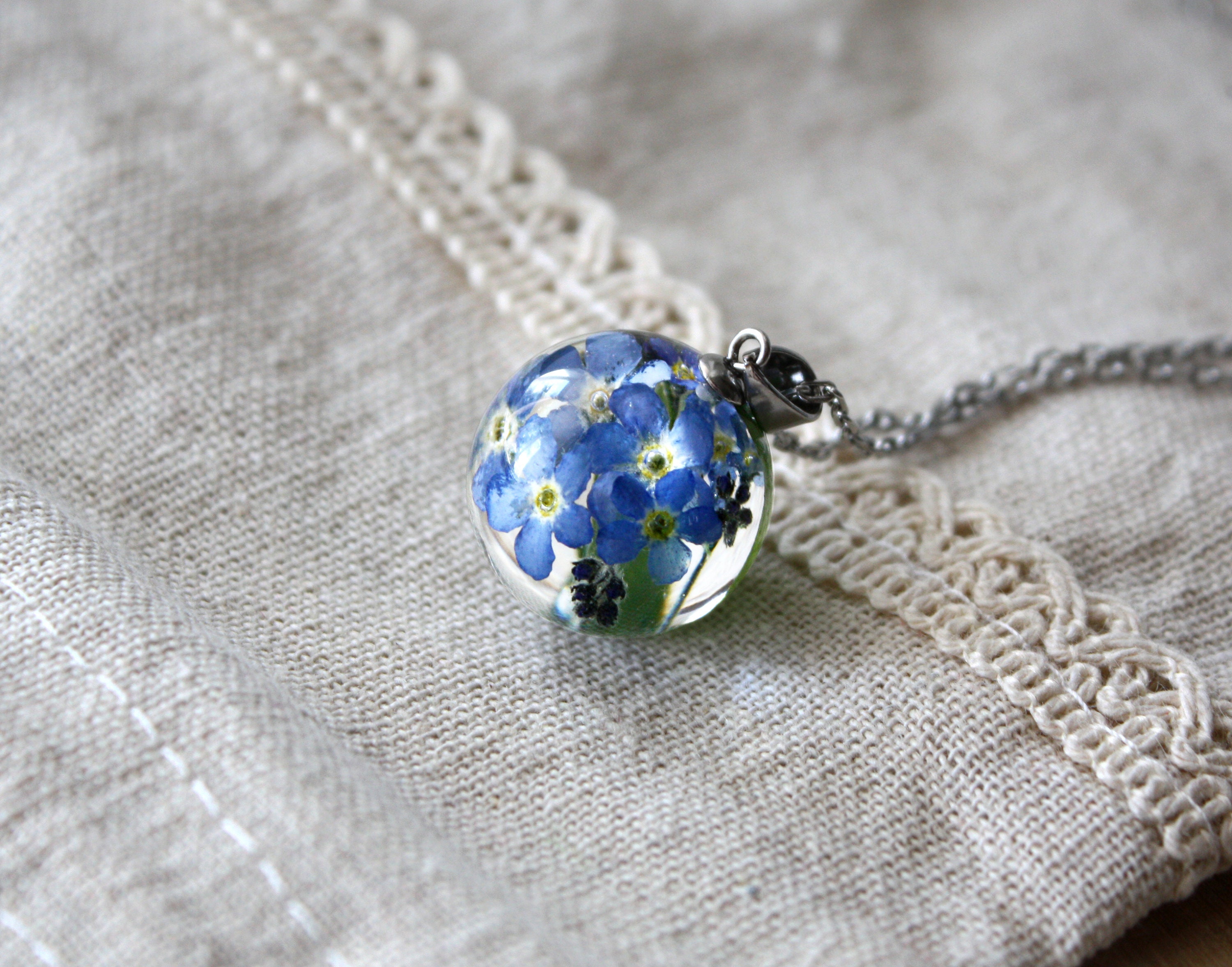 Delicate transparent resin pendant with real Forget Me Nots encased