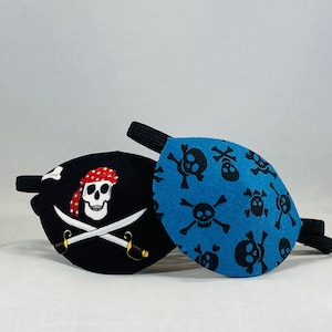 May include: Two pirate eye patches. One is black with a white skull and crossbones and a red bandana. The other is blue with a white skull and crossbones pattern.