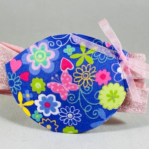 Può includere: Un cerotto per l'occhio blu con stampa floreale e nastro rosa. Il cerotto è fatto di tessuto ed è morbido e confortevole.