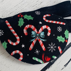 以下が含まれることがあります： クリスマスキャンディーケーンとホーリー柄の黒いアイパッチ。アイパッチは調節可能なストラップ付きです。