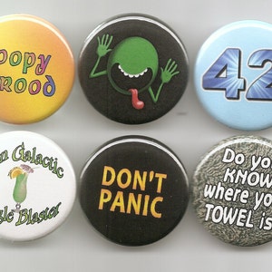 May include: Six round buttons with various designs and text. The buttons are yellow, black, blue, white, black, and gray. The text on the buttons includes "hoopy frood", "Pan Galactic Gargle Blaster", "DON'T PANIC", "42", and "Do you KNOW where your TOWEL is?"