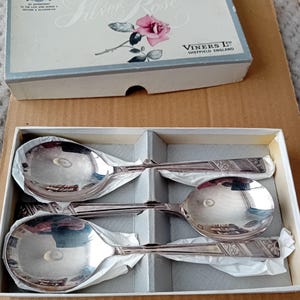 May include: Set of three silver spoons in a box. The spoons have a floral design and the box says "Silver Rose" and "Viners Ltd. Sheffield England."
