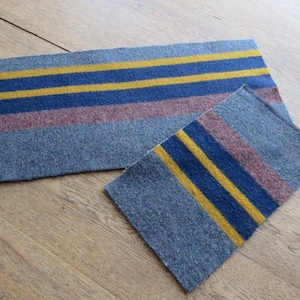 May include: A set of three ceramic mugs with a speckled, matte finish. Each mug features a different color: light blue, cream, and gray. The mugs have a simple, modern design with a rounded shape and a comfortable handle.