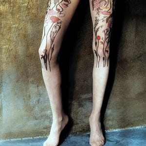 Printed tights with colorful wildflower design on legs features flowers and leaves with pink, red, and yellow accents.