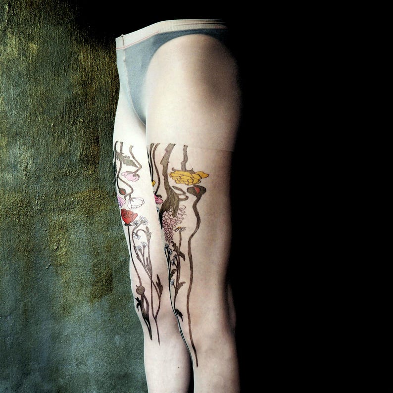 May include: A pair of sheer tights with a floral design printed on the legs. The design features stylized flowers in shades of pink, yellow, and brown.