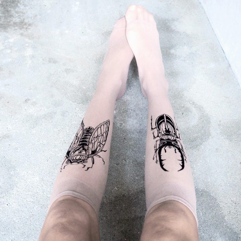 Hand-painted tattoo socks featuring intricate cicada and beetle artwork, perfect for entomology lovers, bug enthusiasts, and goblincore fashion. These unique, nature-inspired socks create a realistic tattoo illusion, combining art and style in wearable form. A thoughtful and quirky insect-themed gift for those who appreciate novelty and handcrafted designs.
