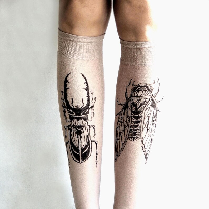 Hand-painted tattoo socks featuring intricate cicada and beetle artwork, perfect for entomology lovers, bug enthusiasts, and goblincore fashion. These unique, nature-inspired socks create a realistic tattoo illusion, combining art and style in wearable form. A thoughtful and quirky insect-themed gift for those who appreciate novelty and handcrafted designs.