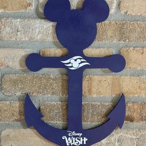 May include: A blue wooden anchor with Mickey Mouse ears and the Disney Wish logo. The anchor has a white Disney cruise line logo and the text "Disney Wish 2025".