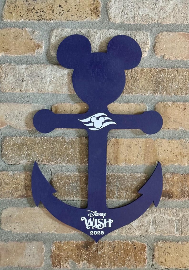 May include: A blue wooden anchor with Mickey Mouse ears and the Disney Wish logo. The anchor has a white Disney cruise line logo and the text "Disney Wish 2025".