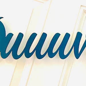 May include: Teal blue wooden sign with the text "#Duuval" in a cursive font.
