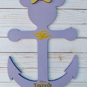 May include: Purple wooden anchor with a gold Mickey Mouse head and the words "Disney Fantasy 2019" on the bottom. The anchor has a bow on top and a gold Mickey Mouse head on the crossbar.
