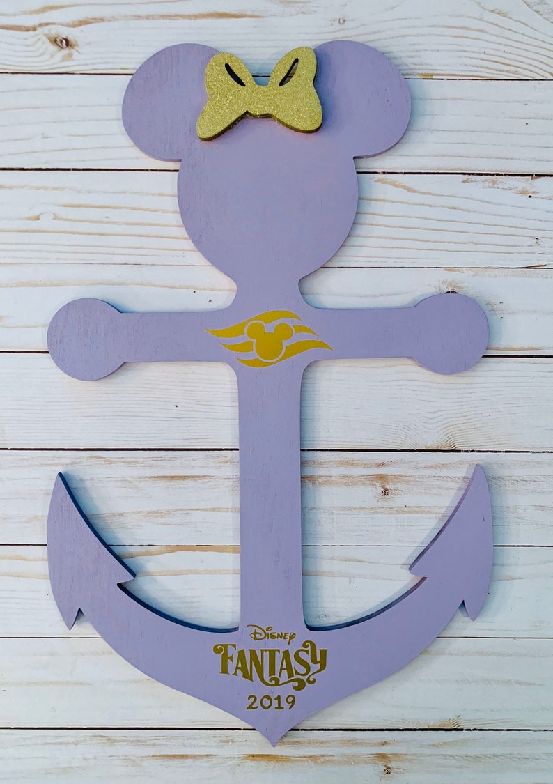 May include: Purple wooden anchor with a gold Mickey Mouse head and the words "Disney Fantasy 2019" on the bottom. The anchor has a bow on top and a gold Mickey Mouse head on the crossbar.