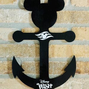 May include: Black wooden anchor shaped like Mickey Mouse with a white Disney Wish logo and the year 2025.