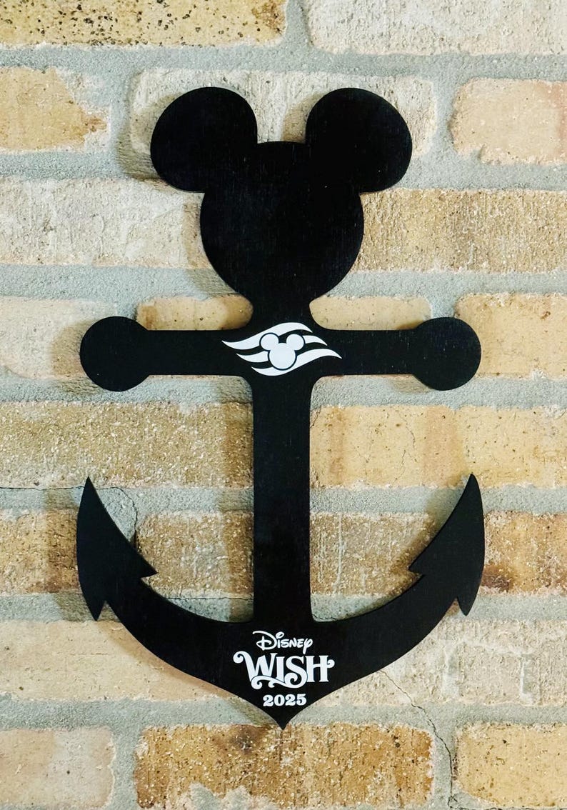 May include: Black wooden anchor shaped like Mickey Mouse with a white Disney Wish logo and the year 2025.