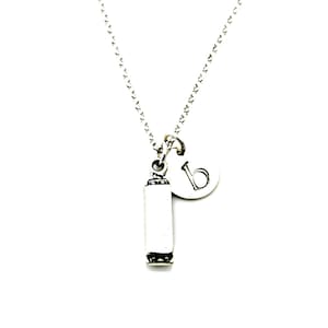 May include: A silver necklace with a small harmonica charm and a letter 'B' charm.