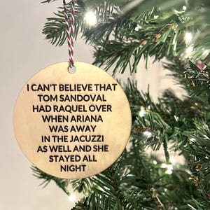 May include: A round wooden ornament with the text "I can't believe that Tom Sandoval had Raquel over when Ariana was away in the jacuzzi as well and she stayed all night".