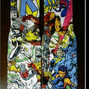 May include: A pair of white socks with a colorful comic book print featuring characters from the X-Men. The socks have a pink trim and the text "30th Anniversary" is visible on one sock.