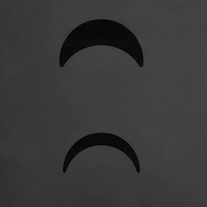 May include: Two black crescent moon shapes on a grey background.
