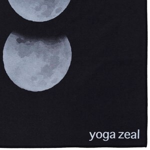 May include: Black yoga mat with a white moon design and the text "yoga zeal" in white at the bottom.
