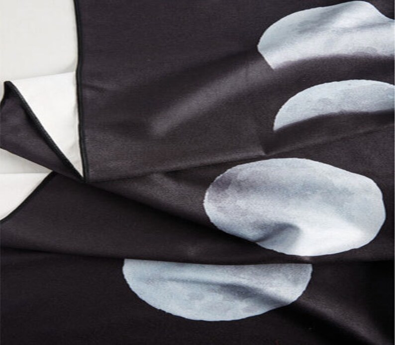 May include: Black tapestry with a white moon phase design. The tapestry features four different phases of the moon, each with a slightly different shade of white.