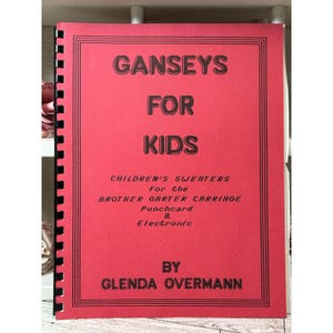 May include: A red spiral-bound instructional book titled GANSEYS FOR KIDS, CHILDREN'S SWEATERS for the BROTHER GARTER CARRIAGE Punchcard & Electronic BY GLENDA OVERMANN. The cover features black text and a double-line border design.
