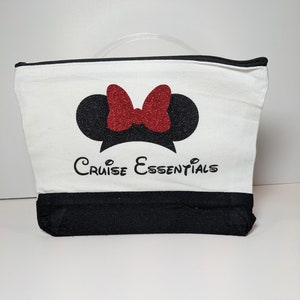 May include: White canvas zippered pouch with a black bottom. The pouch features a black and red Minnie Mouse silhouette with glitter accents and the text "Cruise Essentials".
