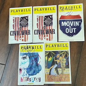 Puede incluir: Una colección de diez programas Playbill de espectáculos de Broadway, incluyendo "The Civil War", "Movin' Out", "Hairspray" y "Dirty Rotten Scoundrels". Cada programa presenta el título de un espectáculo diferente y una firma de un miembro del reparto.