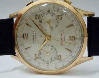 Könnte beinhalten: Eine goldfarbene Chronographen-Armbanduhr mit weißem Zifferblatt. Die Uhr hat ein schwarzes Lederarmband und trägt die Aufschrift "VERBEANA 17 RUBIS" und "ANTI-MAGNETIC  RESSORT INCASSABLE  SUISSE".