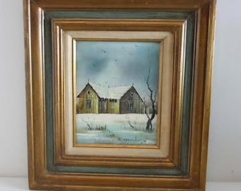 May include: A framed painting of a winter scene with two yellow houses and a snowy landscape. The painting is signed "E. Larsen" in the bottom right corner.