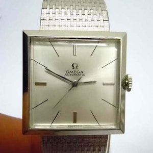 May include: A silver Omega Automatic wristwatch with a square face and a silver mesh band.