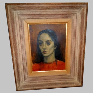 May include: A framed oil painting of a woman with dark hair and a red shirt. The woman is looking to the left of the painting. The painting is signed "M. Smith" in the bottom right corner.