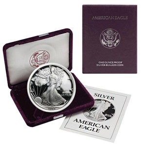 May include: A silver American Eagle proof coin in a velvet box with a certificate of authenticity. The coin features Lady Liberty walking with a torch and an olive branch. The coin is dated 1988. The certificate reads "One Ounce Proof Silver Bullion Coin" and "American Eagle".