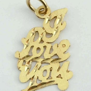 May include: A gold charm pendant with the words "I love you" in a cursive script. The charm has a diamond-cut design and a loop for attaching to a chain.
