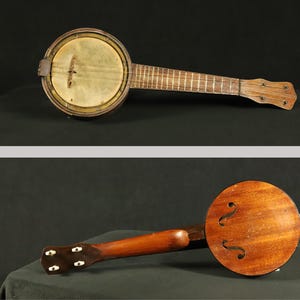 May include: A vintage wooden banjo with a round, wooden body and a long, wooden neck. The banjo has a single string and a metal tuning peg.