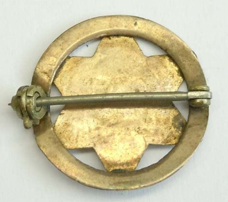 K&ouml;nnte beinhalten: Goldfarbener Metallstift mit einem sechszackigen Sternmuster. Der Stift hat einen Sicherheitsverschluss auf der R&uuml;ckseite.