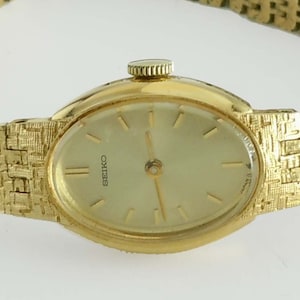 Woman&#39;s Seiko 11-8569 Oval Gold Tone Champagne Stick Dial Statement Watch  Manual Wind Up Mechanical Movement (NO Battery)