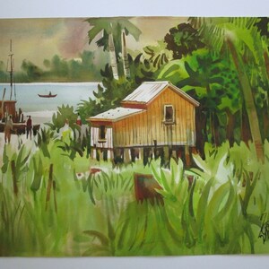 May include: Watercolor painting of a small wooden house on stilts in a tropical setting. The house is painted yellow with a white roof and has a single window. The house is surrounded by lush green foliage and palm trees. A small boat is visible in the distance on a body of water.