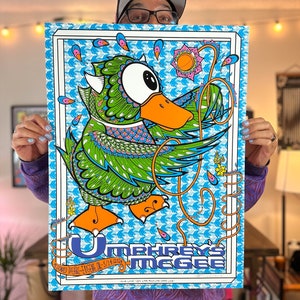 May include: A vibrant poster featuring a whimsical duck illustration with intricate green, blue, and orange patterns. The poster includes the text "Umphrey's McGee" and event details. The background is a light blue pattern with a white border.