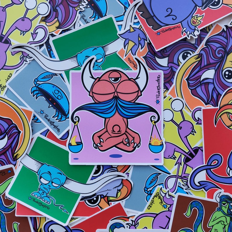 Peut inclure: Une collection d'autocollants color&eacute;s repr&eacute;sentant divers personnages de dessins anim&eacute;s, dont une cr&eacute;ature rose avec une moustache bleue et des &eacute;cailles, un crabe bleu et une cr&eacute;ature violette avec une couronne. Les autocollants sont imprim&eacute;s avec le texte "Powderpuffmonsters" et "Love Powderpuffmonsters".