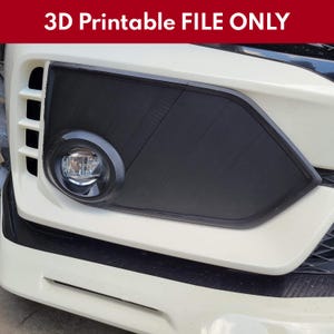以下が含まれることがあります： 車のフロントエンドのクローズアップ。黒い3Dプリントのフォグランプカバーが特徴です。カバーは白い車に取り付けられており、上部には赤で「3D Printable FILE ONLY」と書かれています。フォグランプは黒い円形のフレーム内に見えます。