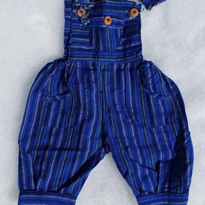 Puede incluir: Pantal&oacute;n vaquero de beb&eacute; a rayas azules y blancas con dos botones de madera. El pantal&oacute;n tiene dos bolsillos en la parte delantera.